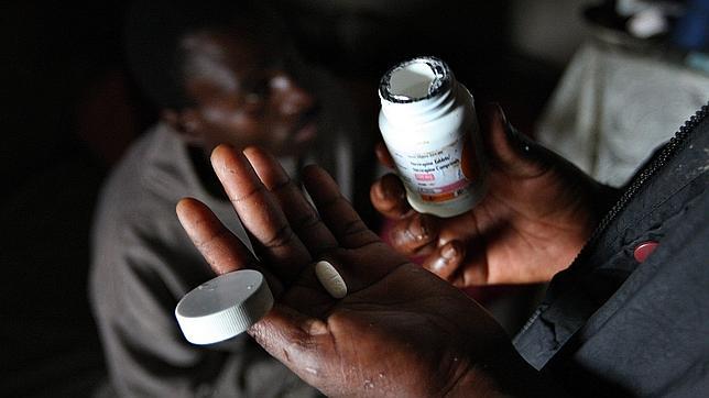 Una mujer reparte las pastillas contra el VIH a su pareja en Mbabane(Suazilandia) - EPA